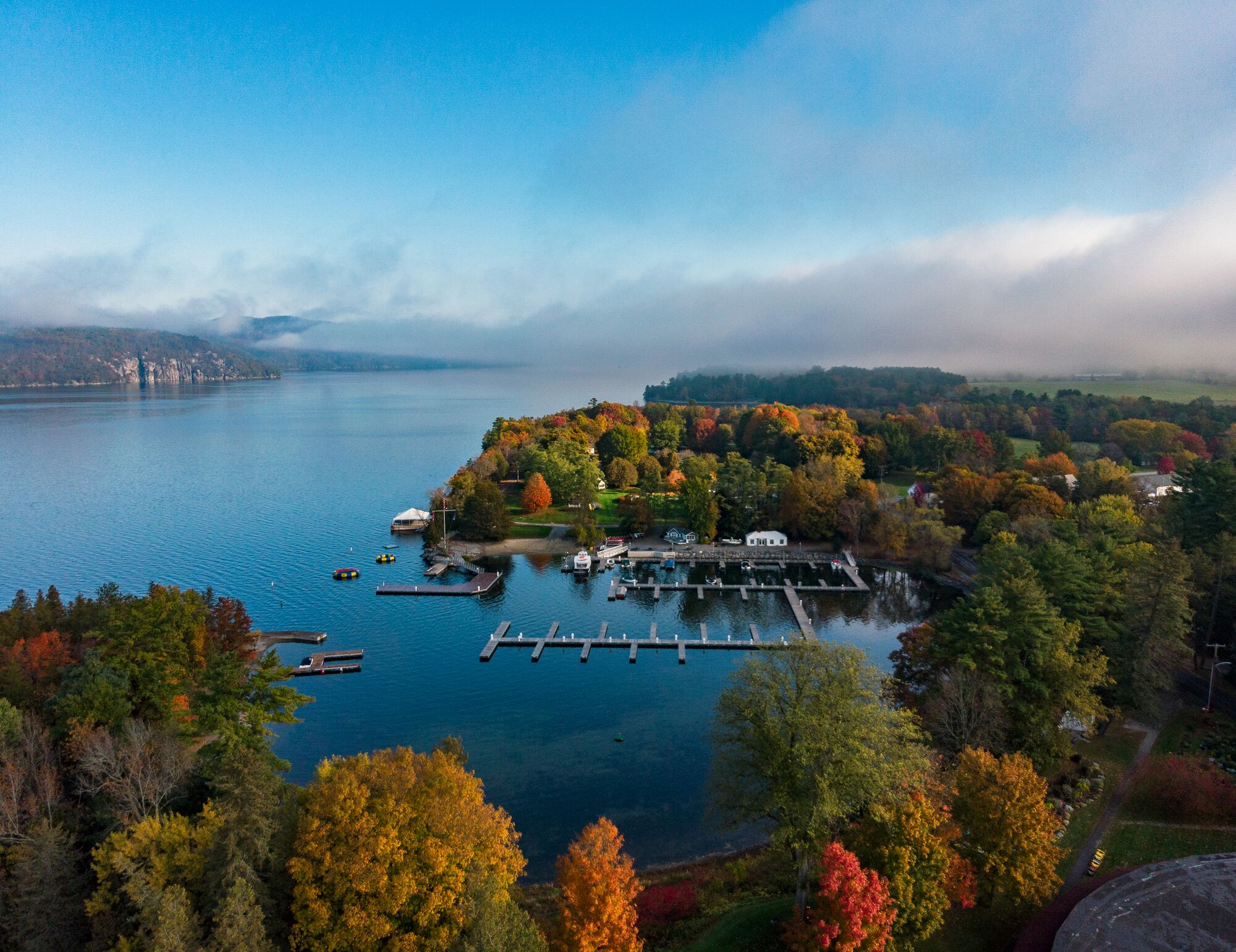 Ariel view of a large lake surrounded by trees in the fall.