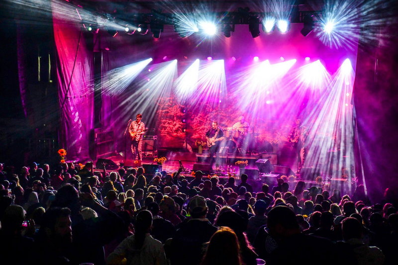 Bright lights illuminate a concert at night.