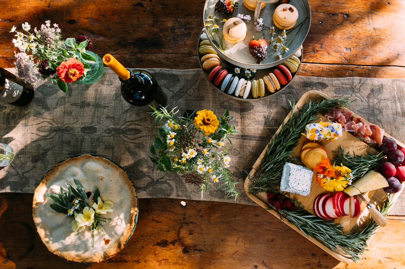 Seen from above, a table set with colorful food outdoors in the summer.