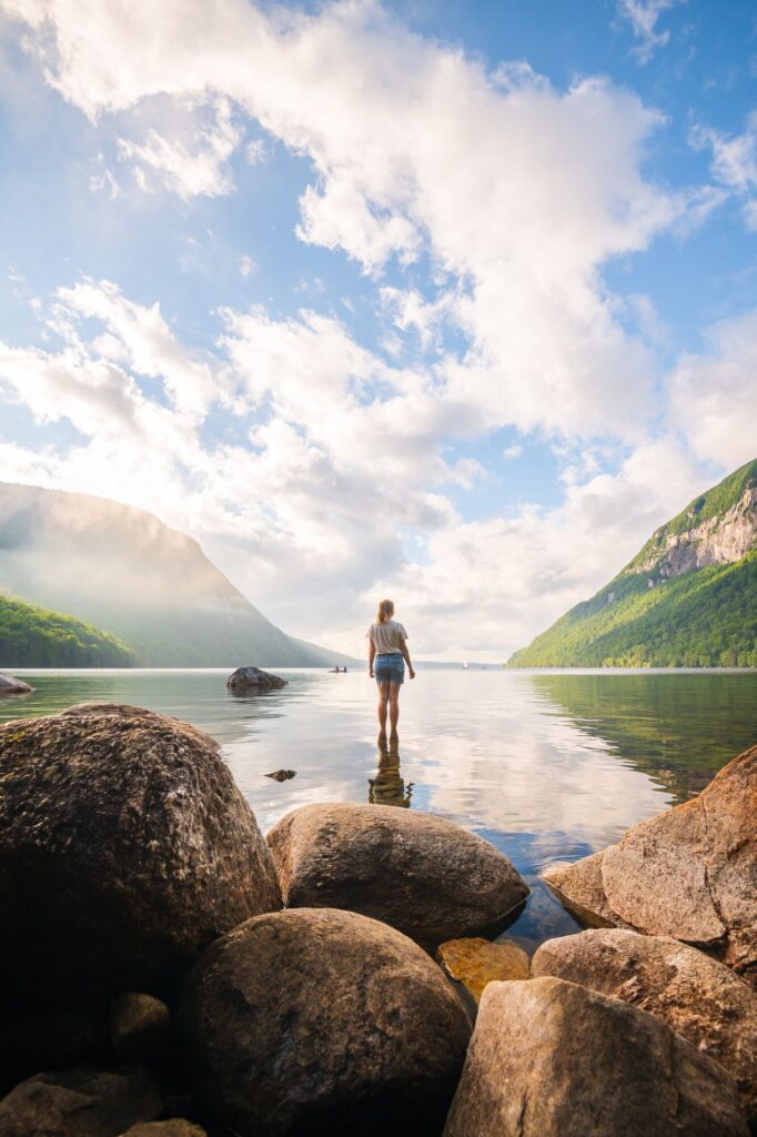 A person stands at the shore of a large lake.