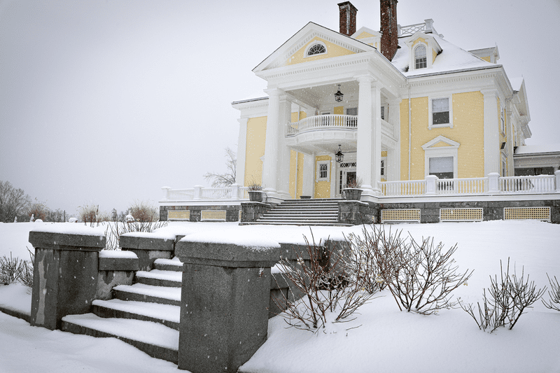 A yellow historic building seen from outside in the winter.