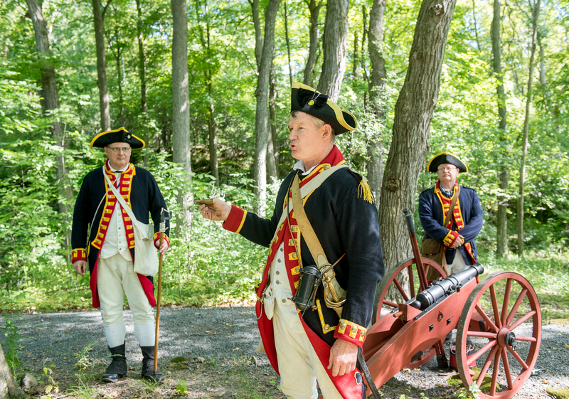 People in reenactment clothing in a forest.