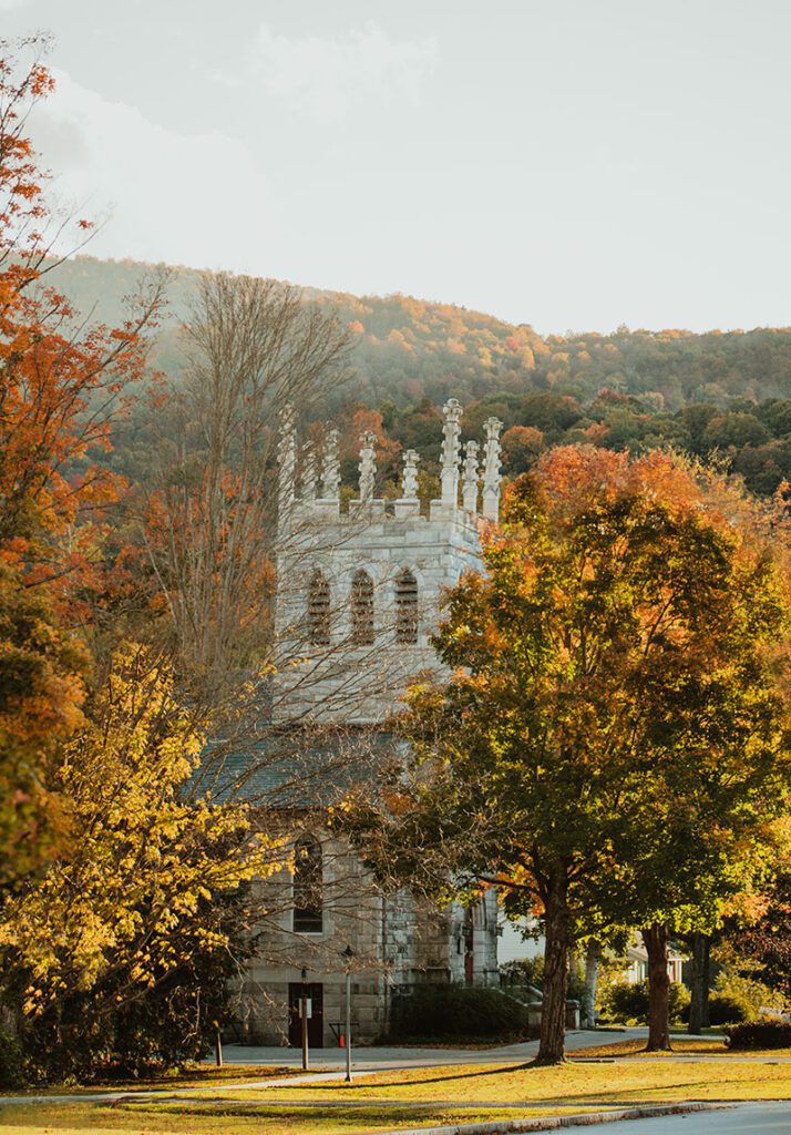 A church in the fall along a stone sidewalk.