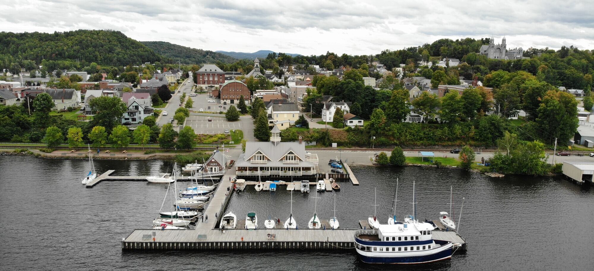 Seen from above, a dock with boats next to a downtown.