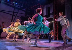 Dancers perform on a stage during a performance.