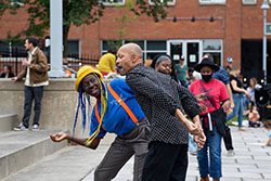 People dance to music outdoors on a summer day.