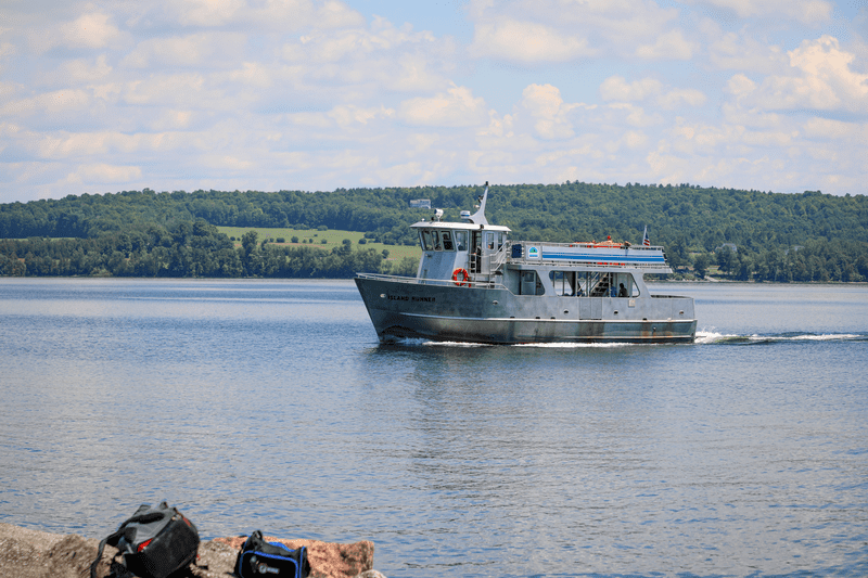 A boat travels across a lake on a sunny day.